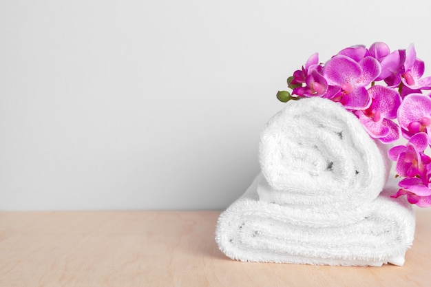 clean soft towels with flower on wooden table