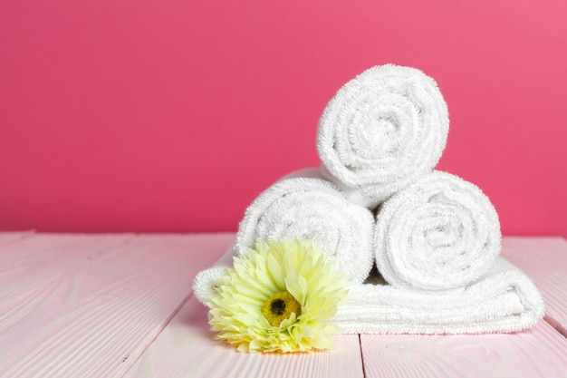 clean soft towels with flower on wooden table