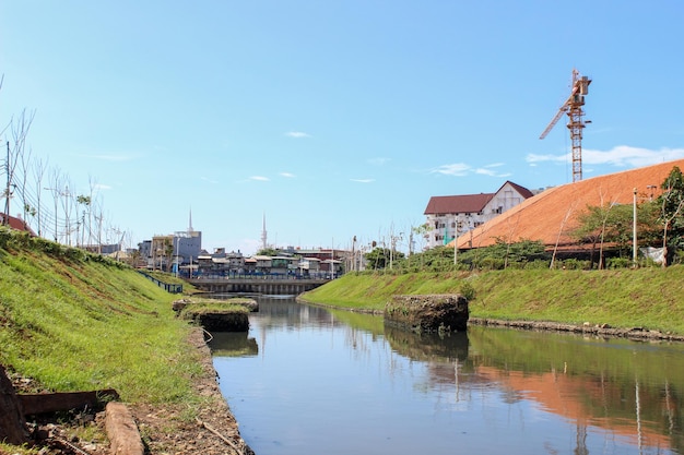 Clean urban river with green grass on the banks