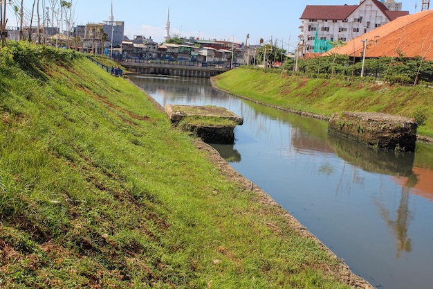 Чистая городская река с зеленой травой на берегу