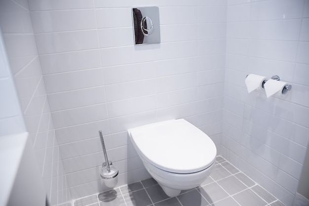 Чистый белый фон ванной комнаты Внутреннее убранство Минималистский стиль, открытое пространство. Реальное фото. Современная белая ванная комната с керамическим туалетом.