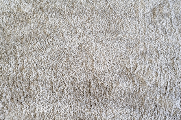 A clean white color carpet on the floor at home in living room, textile texture