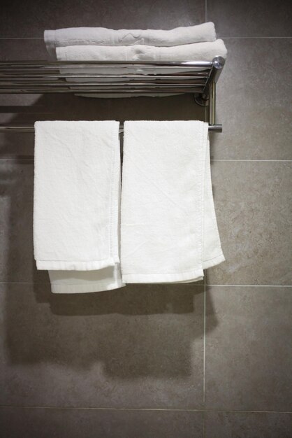 Чистое белое полотенце на вешалке, готовое к использованию