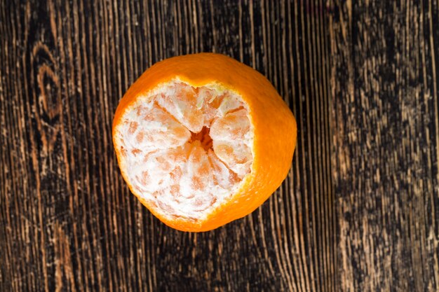 Photo cleaned from the peel tasty oranges are ready for eating, the pieces lying on the table