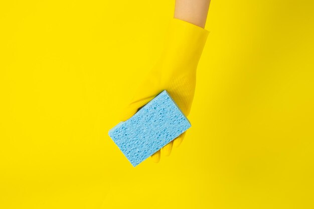 Cleaner concept Hand in rubber gloves and holding light blue sponge for cleaning in home