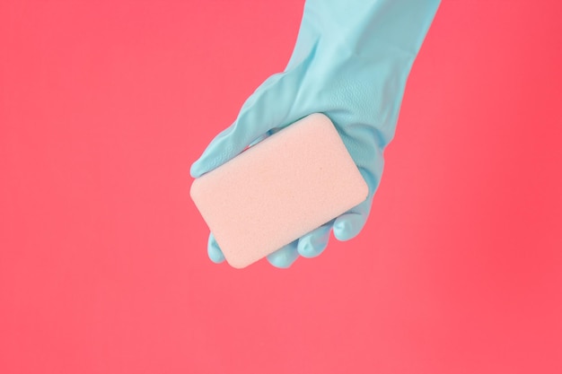 Cleaner concept Hand in rubber gloves and holding soap for cleaning isolated on pink background