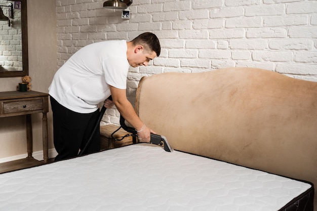 Cleaner is extracting dirt from mattress using dry cleaning extractor machine Cleaning mattress using extractor machine for dry clean at home