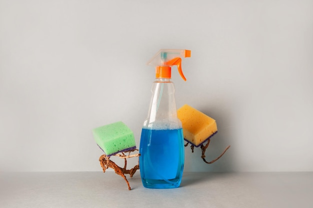 Cleaning agent and colored sponges on a light background