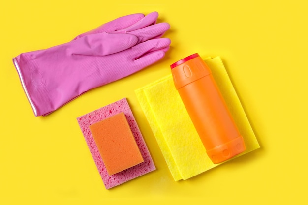 Cleaning agent and washing sponges on yellow background