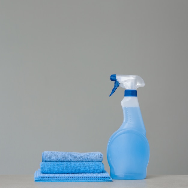 Cleaning blue spray bottle with plastic dispenser and cloth for dust  