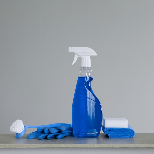 Cleaning blue spray bottle with plastic dispenser, scrubbing brush for dish