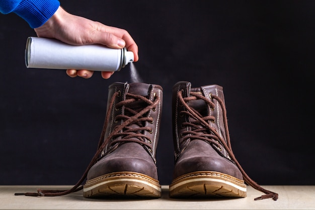 Pulizia degli stivali e rimozione degli odori con spray stivali sporchi con un odore sgradevole. scarpe sudate dopo lunghe camminate e stile di vita attivo. cura delle scarpe