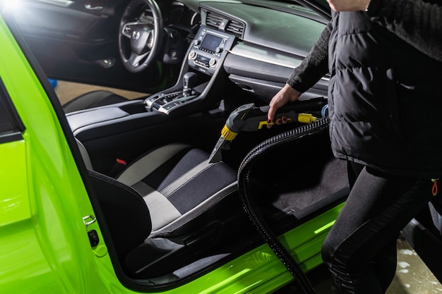 Cleaning car salon dry cleaning with vacuum cleaner.
professional use of a steam vacuum cleaner to remove stains