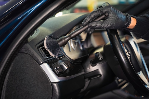 Cleaning car vents with brush.