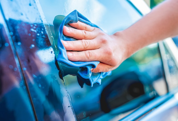 Cleaning car window with microfiber rag