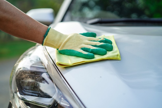 Cleaning car with green color microfiber cloth outdoor in holiday.