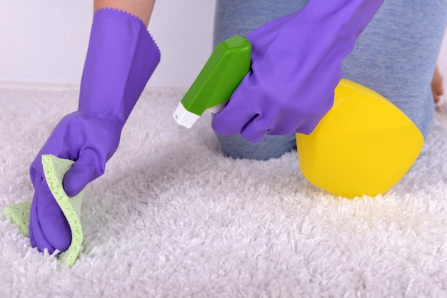 Cleaning carpet with cloth and sprayer close up