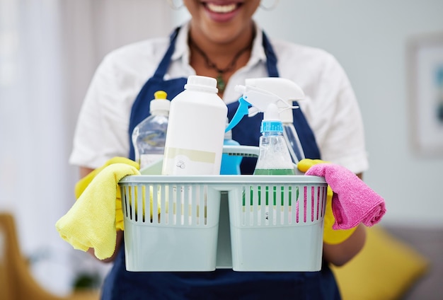 cleaning chemical and basket with hands of woman in living room for hygiene dust and bacteria spray tools and equipment with closeup of female cleaner at home for housekeeping health and product