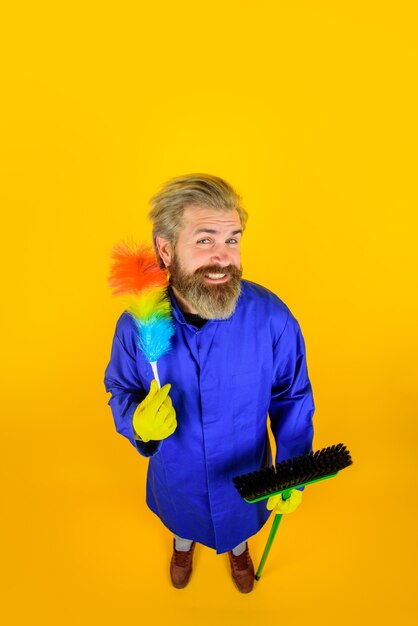 Cleaning clearing tools dust brush household housekeeping smiling man in uniform with dust brush