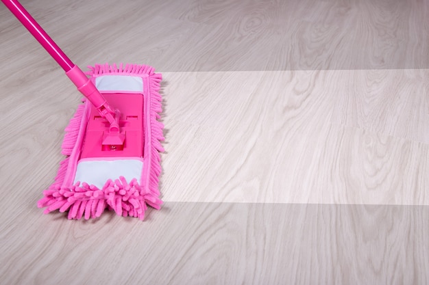 Photo cleaning concept -close up of pink mop cleaning wooden floor