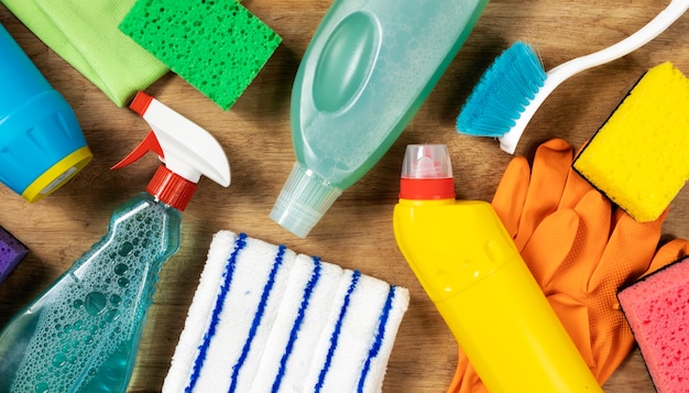 cleaning concept. set of cleaning supplies on wooden table, top view