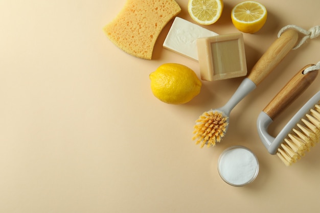 Cleaning concept with eco friendly cleaning tools and lemons on beige isolated background