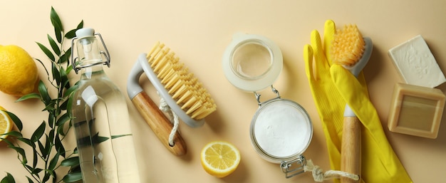 Cleaning concept with eco friendly cleaning tools and lemons on beige isolated background