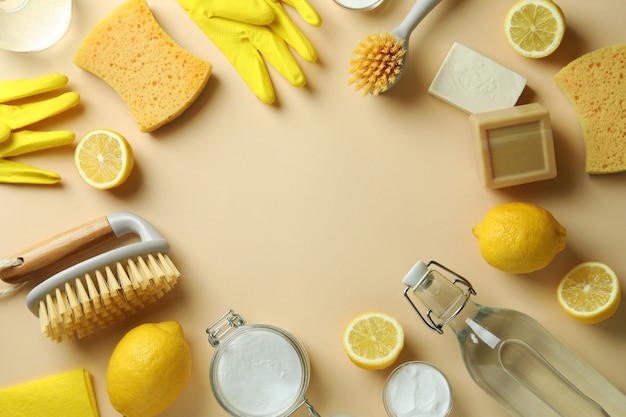 Cleaning concept with eco friendly cleaning tools and lemons on beige isolated background