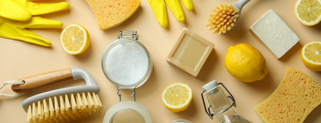 Cleaning concept with eco friendly cleaning tools and lemons on beige isolated background