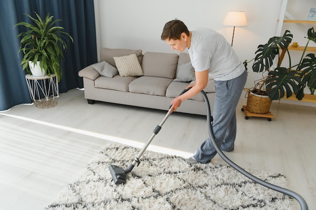 Cleaning concept woman cleaning carpet with vacuum cleaner