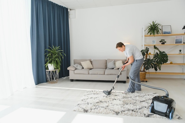 Cleaning concept woman cleaning carpet with vacuum cleaner