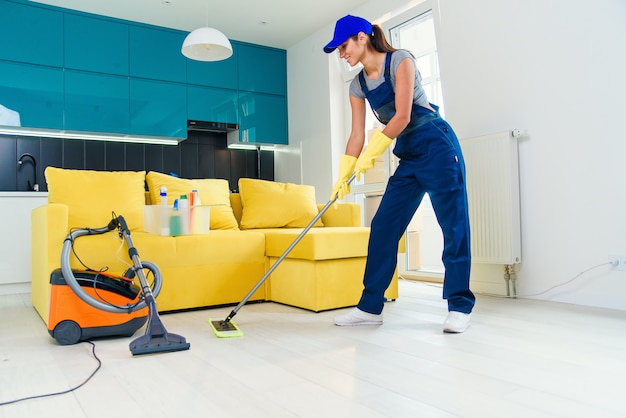 Cleaning concept. Young woman washing floor on the kitchen