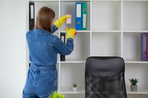 Cleaning concept young woman with supplies cleaning office