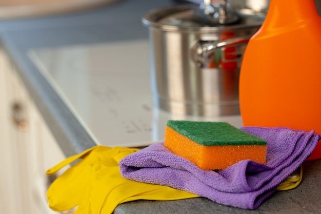 Cleaning detergents and tools on a kitchen counter 