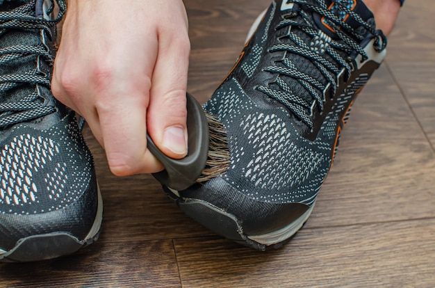 Pulizia delle scarpe da ginnastica sporche dopo l'allenamento. lava le scarpe da ginnastica sporche. lava le tue scarpe da ginnastica. pulisci la tua scarpa da trail running.