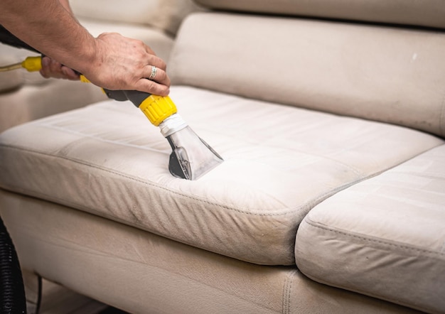 Cleaning a dirty sofa with a sofa washer Close up of hands holding sofa cleaner Professional sofa wash Sofa wash image