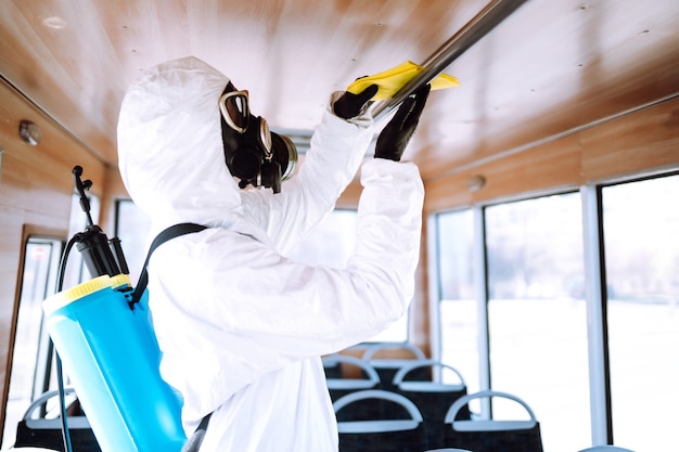 Cleaning and Disinfection public transport. Man in protective suit washing and disinfection public transport.