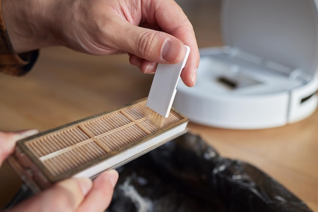 Cleaning the filter of the vacuum robot cleaner from dirt closeup