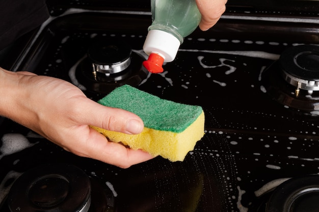 Cleaning the gas stove with soapy water. cleaning the kitchen.