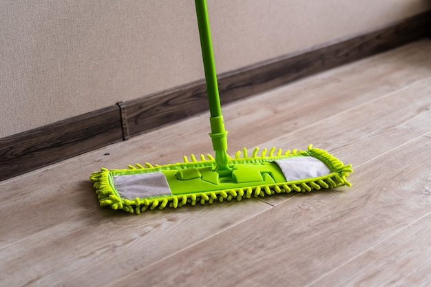 Cleaning gear. Mopping a living room floor. Green mop.