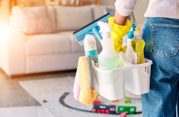 Cleaning hand and basket of cleaning supplies for family home hygiene with a brush bottles and gloves Woman cleaning supplies and housekeeper about to clean a home for spring cleaning