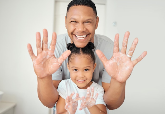 Pulizia delle mani e ritratto di famiglia felice di padre e figlia che si lavano le mani in bagno a casa relax e allegri cure igieniche e palme fresche su genitori e figli che si divertono e giocano con il sapone