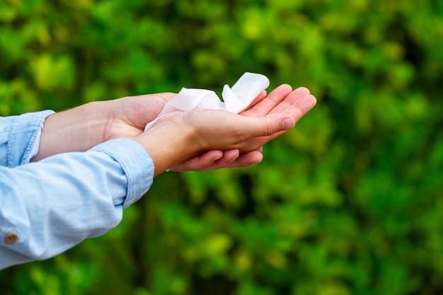 Cleaning hands with wet wipes in park