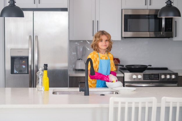 Cleaning at home portrait of child cleaning in the kithen child housekeeper washing the dishes on so