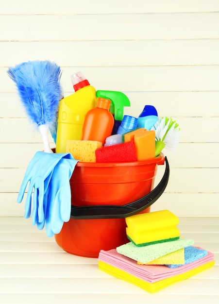 Cleaning items in bucket on white wooden background