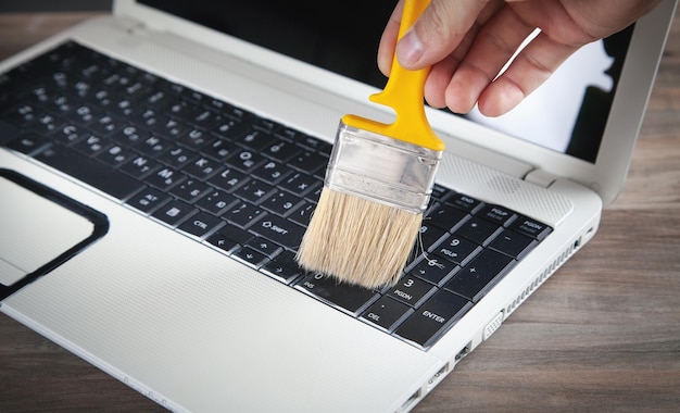 Cleaning the keyboard from dust and dirt with a brush.