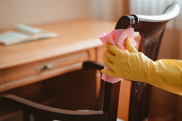 Cleaning and maintenance of wooden chair table with rag and cleaning agent