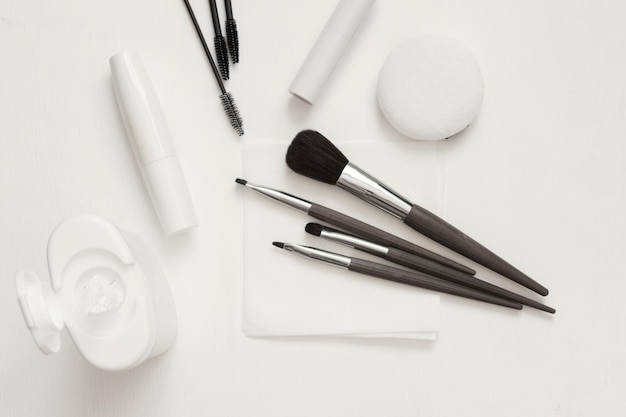 Cleaning makeup brushes with special disinfecting cloth Tools on table top view flatlay