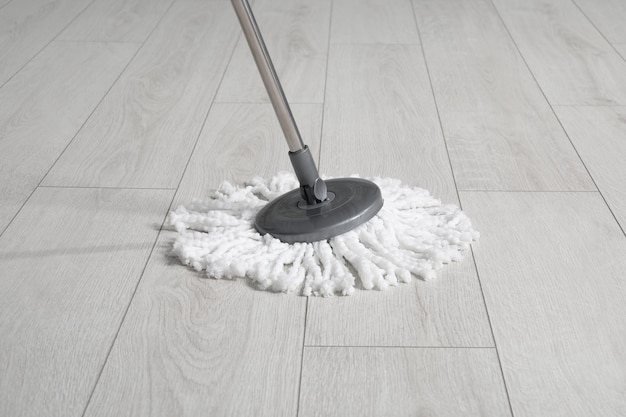 Photo cleaning of parquet floor with mop indoors