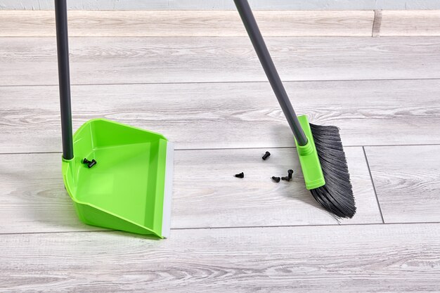 Cleaning process with modern brush and a broom in apartment